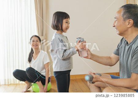 自宅で運動する祖父母と孫 自宅で運動する祖父母と孫 123985805