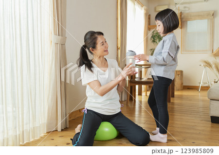 自宅で運動する祖母と孫 123985809