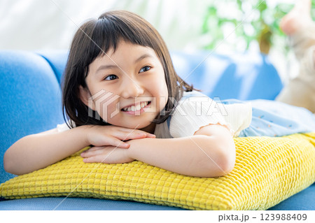 ソファに寝転がる小学生の女の子 123988409