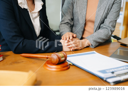 Business people compassionately holding hands and discussing contract papers Business people compassionately holding hands and discussing contract papers 123989016