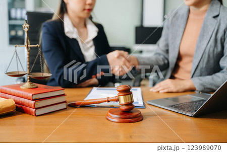 Two lawyers are discussing about contract paper, law matters determination, pointing.law and hammer Two lawyers are discussing about contract paper, law matters determination, pointing.law and hammer 123989070