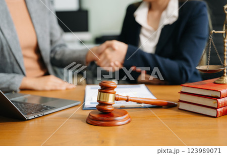 Two lawyers are discussing about contract paper, law matters determination, pointing.law and hammer Two lawyers are discussing about contract paper, law matters determination, pointing.law and hammer 123989071