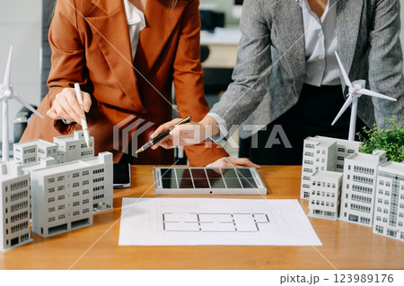 Modern office meeting of architects, designers, and developers creating innovative, sustainable housing projects Modern office meeting of architects, designers, and developers creating innovative, sustainable housing projects 123989176