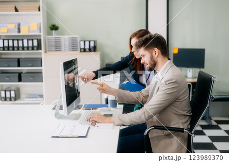 Two busy happy professional business man and woman executive leaders team using laptop working 123989370