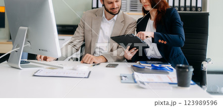 Two busy happy professional business man and woman executive leaders team using laptop working 123989596