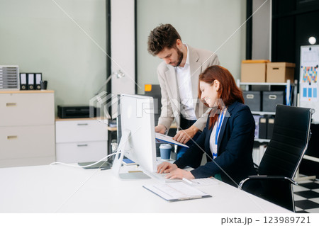Two busy happy professional business man and woman executive leaders team using laptop working 123989721