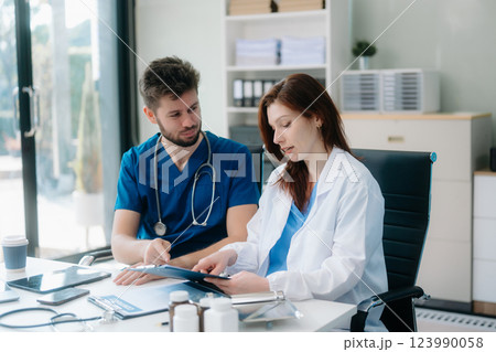 Doctors analyzing results or diagnosis of patient in clinic. Teamwork, medical and healthcare workers Doctors analyzing results or diagnosis of patient in clinic. Teamwork, medical and healthcare workers 123990058
