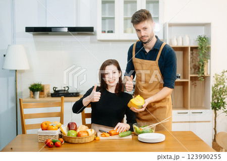 Couple cooking at home. young couple cooking together with Bread and fruit fresh vegetables, embracing healthy eating Couple cooking at home. young couple cooking together with Bread and fruit fresh vegetables, embracing healthy eating 123990255