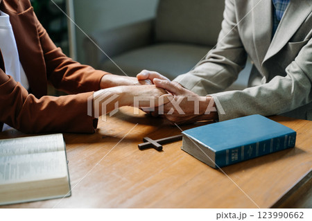 Two people reading and study bible in home and pray together.Studying the Word Of God Two people reading and study bible in home and pray together.Studying the Word Of God 123990662