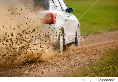Gravel splashing from rally race car drift on track. Gravel splashing from rally race car drift on track. 123990997