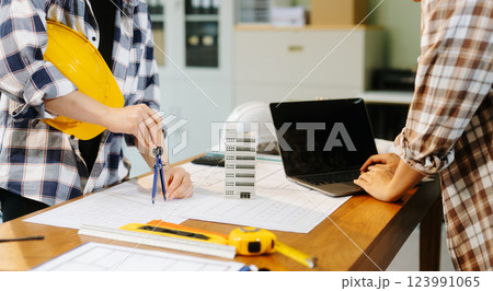 Two colleagues discussing data working and tablet, laptop with architectural project at construction site Two colleagues discussing data working and tablet, laptop with architectural project at construction site 123991065