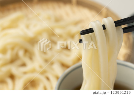 冷たいざるうどんを箸で持ち上げつゆに付ける 123991219
