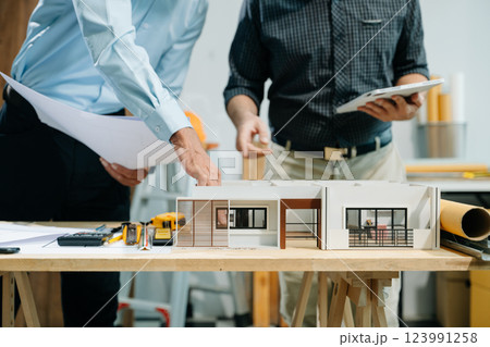 Two colleagues discussing data working and tablet, laptop with architectural project at construction site 123991258