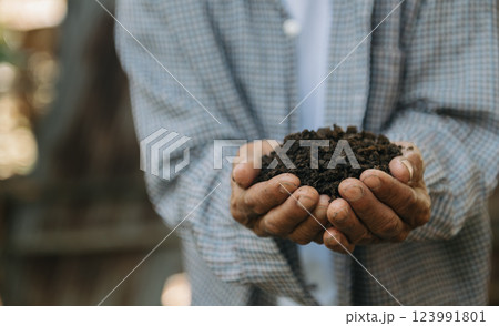 Oldman farmer holding soil in cupped hands 123991801