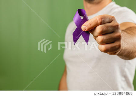 Man holds purple ribbon to raise awareness for important cause 123994869