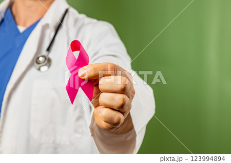 Health professional holding pink ribbon for breast cancer awareness campaign 123994894