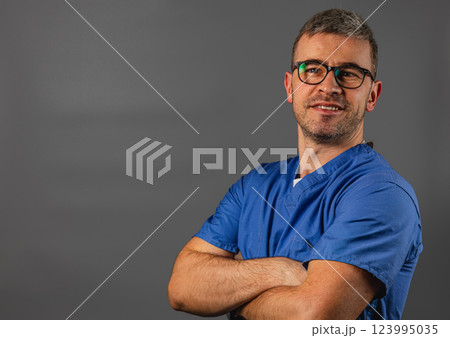 Healthcare professional in blue scrubs smiles confidently at the camera 123995035