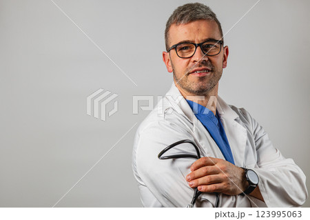 Healthcare professional in a white coat poses confidently with a stethoscope Healthcare professional in a white coat poses confidently with a stethoscope 123995063