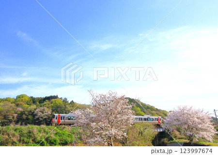 色づき始めた里山を のんびり走る列車 123997674