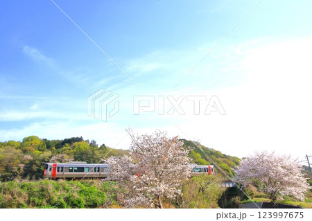 色づき始めた里山を のんびり走る列車 123997675