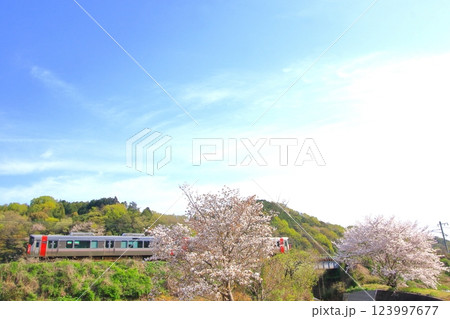 色づき始めた里山を のんびり走る列車 123997677