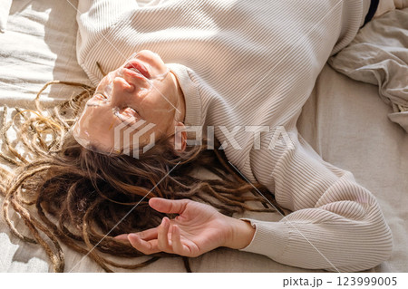 Woman Having Hydrogel Facial Mask While Relaxing On Bed. Woman Having Hydrogel Facial Mask While Relaxing On Bed. 123999005