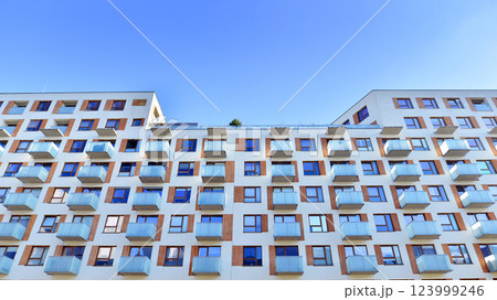 Apartment building with  symmetrical modern architecture in the city. Modern apartment building on a sunny day. Facade of a modern apartment building. Bottom view.  123999246