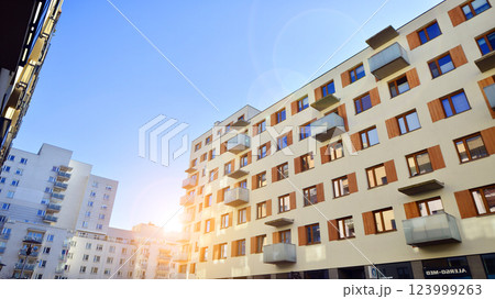 Apartment building with  symmetrical modern architecture in the city. Modern apartment building on a sunny day. Facade of a modern apartment building. Bottom view.  123999263