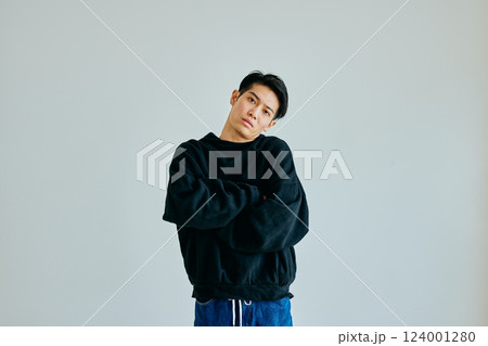 腕組みをしながら首をかしげる20代の若い男性 124001280