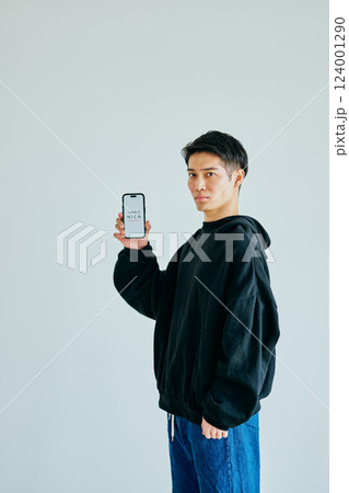 スマホを持つ20代の若い男性 つみたてNISA スマホを持つ20代の若い男性 つみたてNISA 124001290