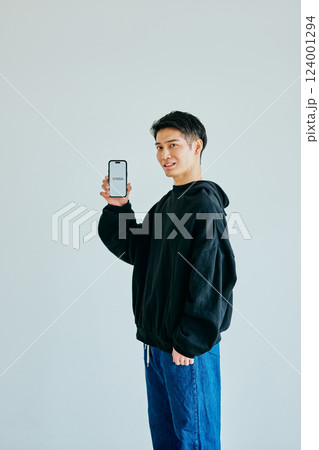 スマホを持つ20代の若い男性　新NISA 124001294