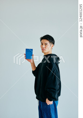 年金手帳を持つ20代の若い男性 124001295
