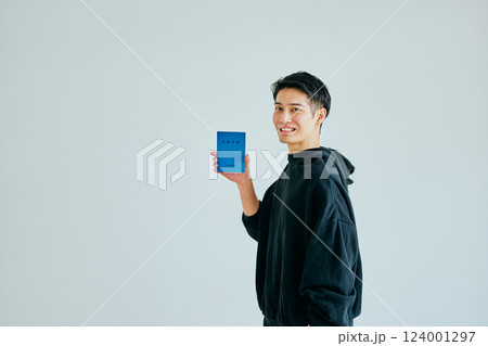 年金手帳を持つ20代の若い男性 年金手帳を持つ20代の若い男性 124001297