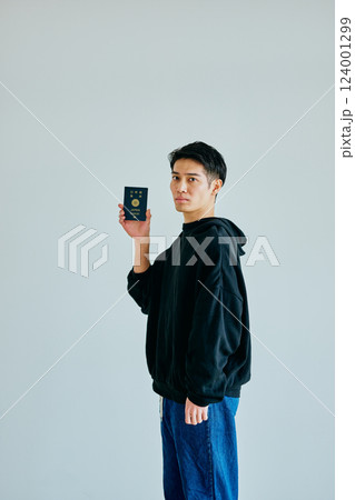 パスポートを持つ20代の若い男性 パスポートを持つ20代の若い男性 124001299