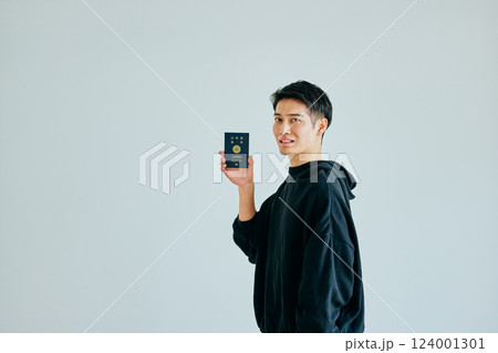 パスポートを持つ20代の若い男性 パスポートを持つ20代の若い男性 124001301