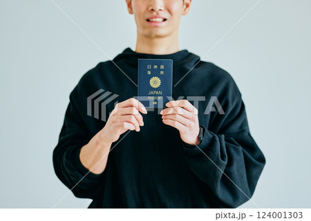パスポートを持つ20代の若い男性 パスポートを持つ20代の若い男性 124001303
