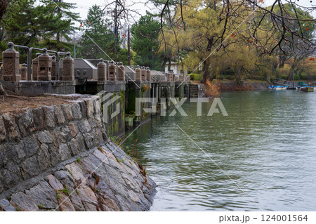 日本の岡山県倉敷市の水路のある公園の雨天の風景 124001564