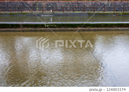 日本の岡山県倉敷市の水路のある公園の雨天の風景 124001574
