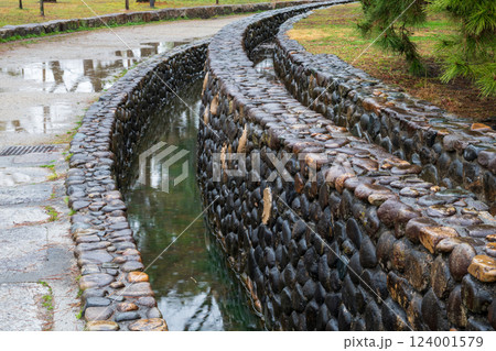 日本の岡山県倉敷市の水路のある公園の雨天の風景 124001579