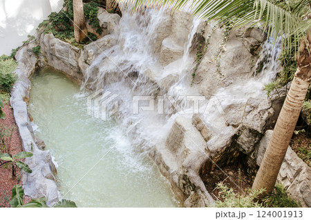 Artificial waterfall. Artistic blur of water, long exposure. Decorations decorative waterfall on the hotel grounds. Artificial waterfall. Artistic blur of water, long exposure. Decorations decorative waterfall on the hotel grounds. 124001913