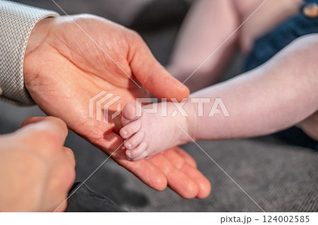 Baby feet in mother hands. Mom and her Child. Happy Family concept. Beautiful conceptual image of Maternity 124002585