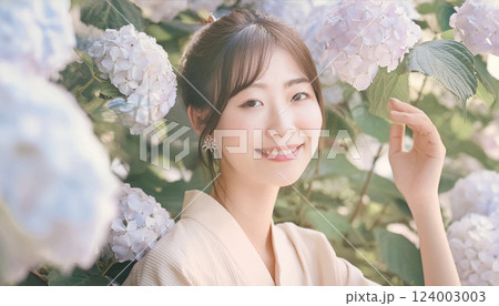紫陽花と着物を着た若い女性。アジサイの花に埋もれた女性のポートレート 124003003