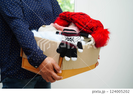 Clothes donations in cardboard box for volunteer. Clothes donations in cardboard box for volunteer. 124005202
