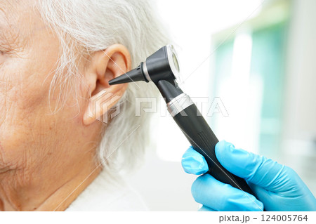 Otolaryngologist or ENT physician doctor examining senior patient ear with otoscope, hearing loss problem. Otolaryngologist or ENT physician doctor examining senior patient ear with otoscope, hearing loss problem. 124005764