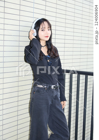 黒いカジュアルなコーディネートをした若い女性のファッションスナップ 124006904