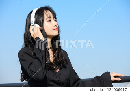 黒いカジュアルなコーディネートをした若い女性のファッションスナップ 124006917