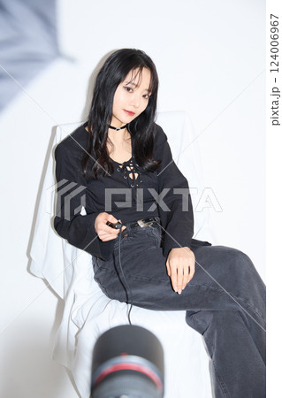 黒いカジュアルなコーディネートをした若い女性のファッションスナップ 124006967