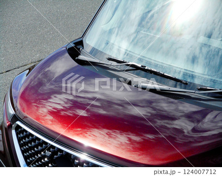 赤い車のボンネットに反射した空 124007712
