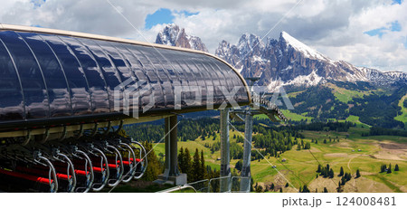 Majestic mountain landscape with ski lift and snow-capped peaks in summer near Valley of Funes at Dolomites, Italy Majestic mountain landscape with ski lift and snow-capped peaks in summer near Valley of Funes at Dolomites, Italy 124008481