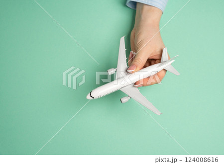 Passenger plane in hand. Air travel. Vacation planning, global mobility. Tourism, business trips, and exploring new destinations. 124008616